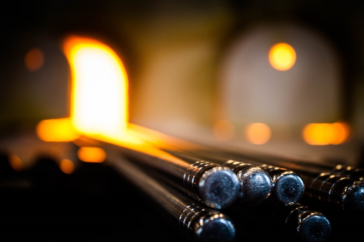 Metal rods with flame visible in the out-of-focus background