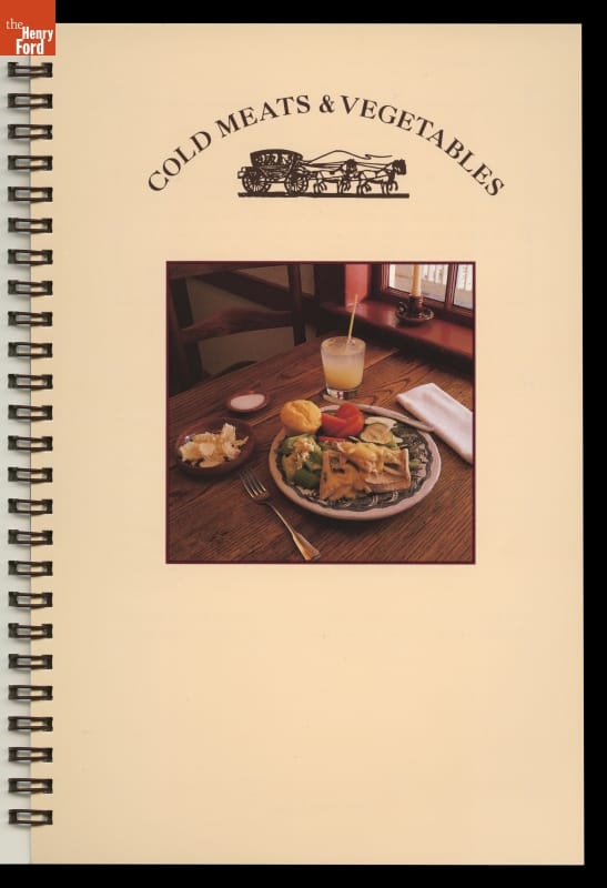 Spiral-bound page with text and image of wooden table set with food and drink
