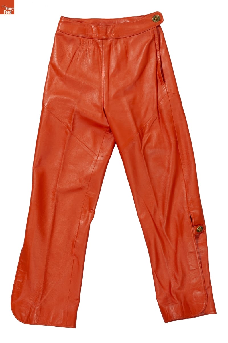 Burnt-orange leather pants with button at side of waist and also at side of knee
