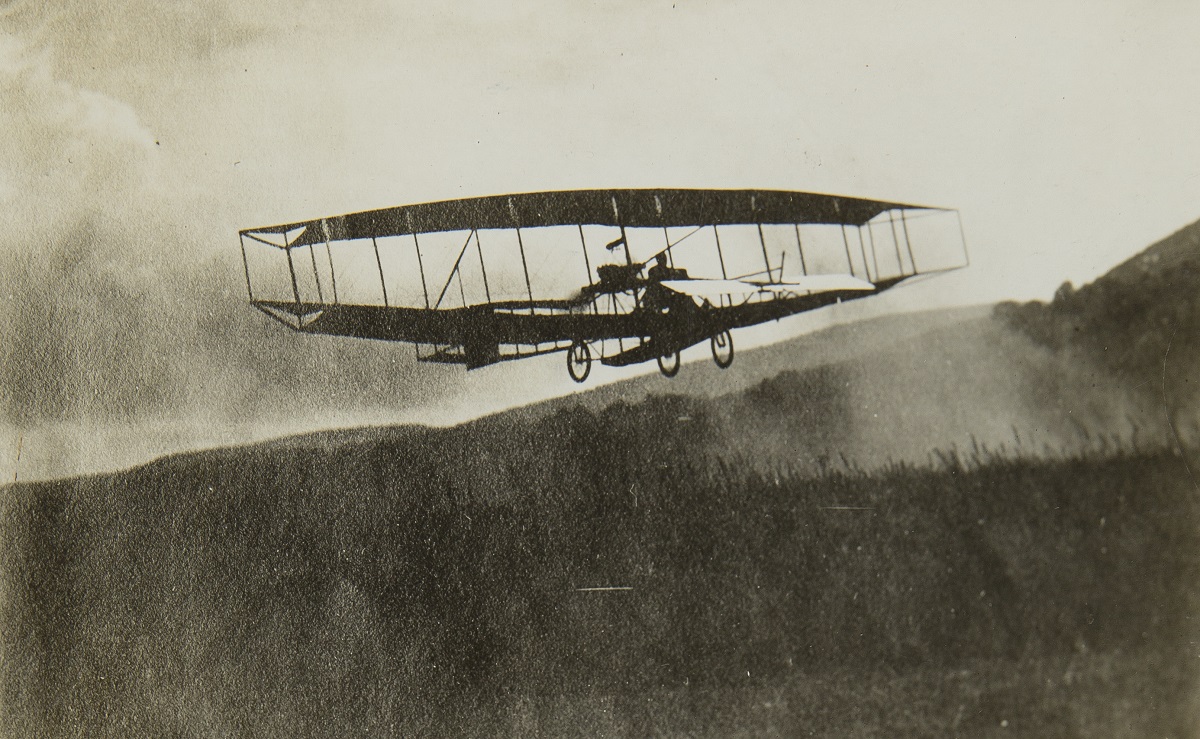 Ernest L. Jones Early Aviation Scrapbook, vol. 1 of 7 (A-B) / page 18 Black-and-white image of early glider in air over a wooded area