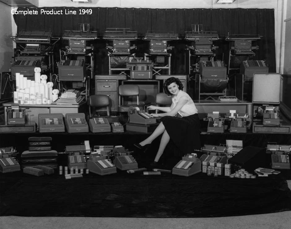 Woman sitting in the middle of a variety of office equipment