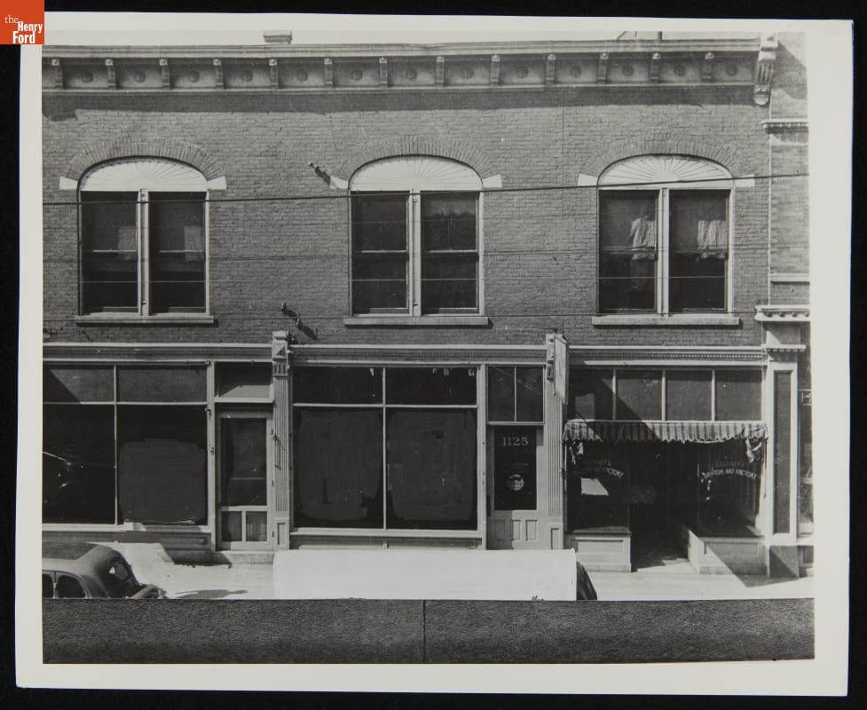 Facade of two-story brick building with storefronts on ground floor and windows on second floor