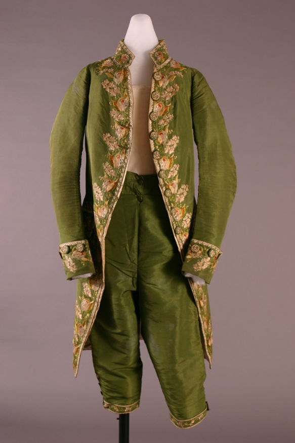 Men's Suit, circa 1800 Moss-green man's suit on mannequin; knee-length breeches and long-open coat with embroidery all along front seams and on cuffs