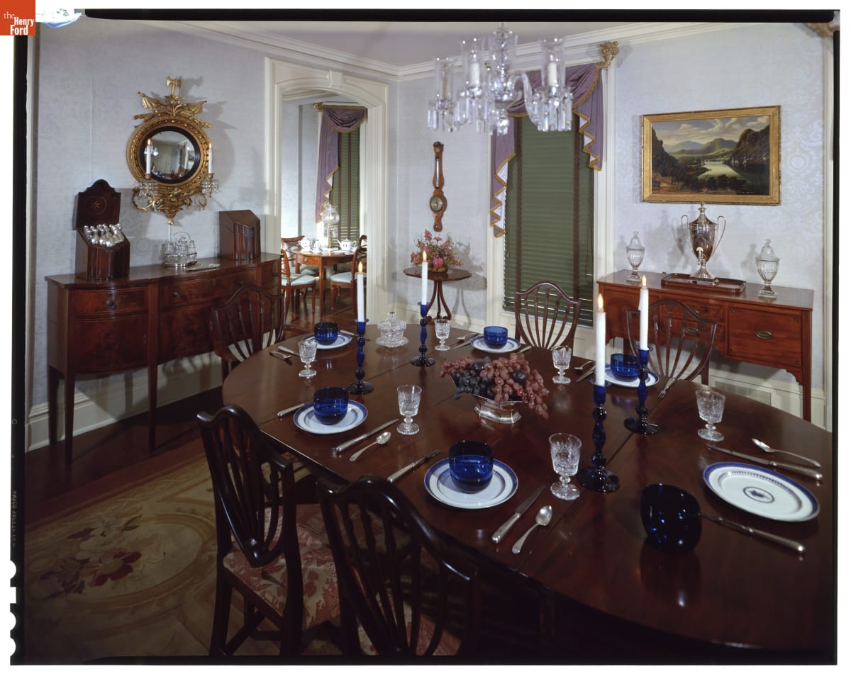 Dining room with elaborate furnishings, including set table and chairs and two sideboards