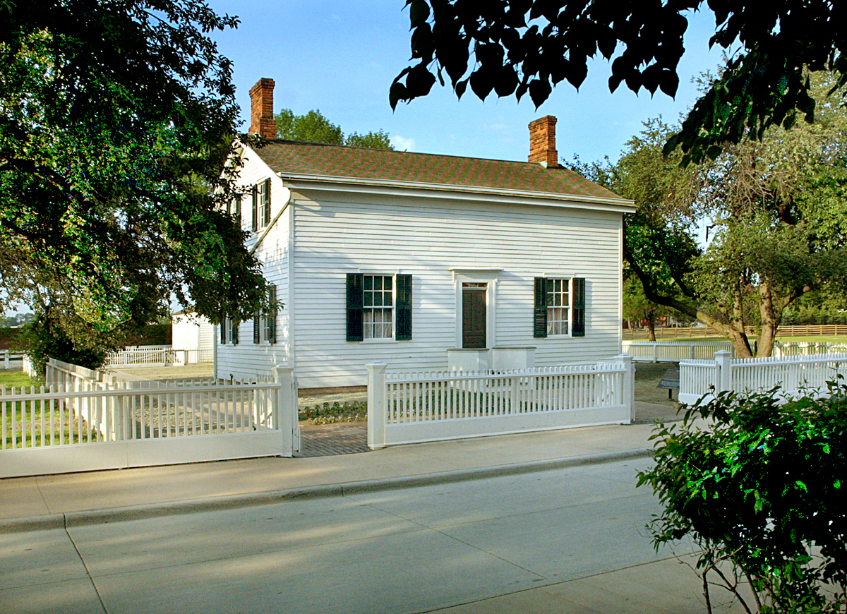 Ford Home White wooden building with white picket fence in front