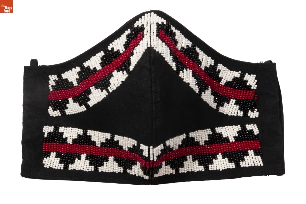 Black fabric face mask with pattern of white, black, and red beads around border
