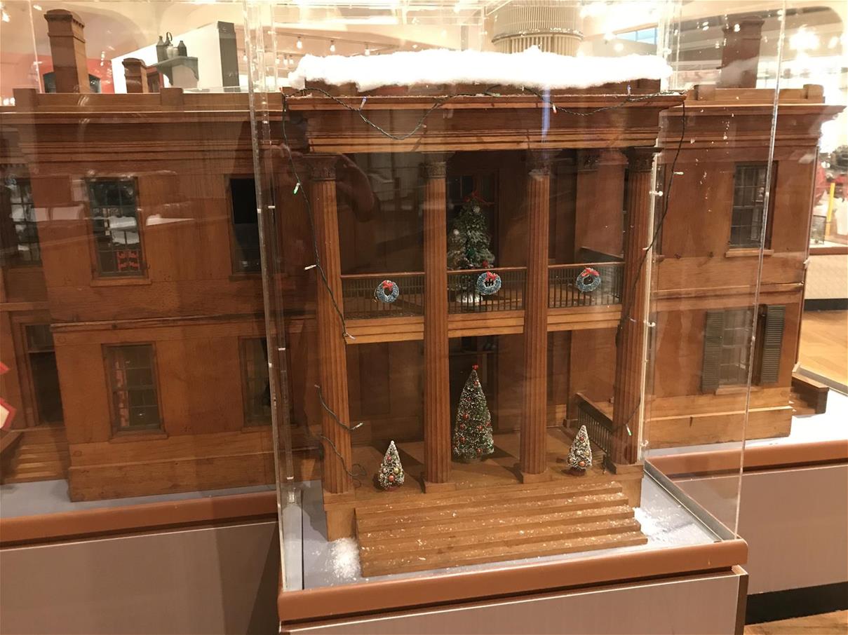 Historic dollhouse in Henry Ford Museum of American Innovation, decorated for the holidays Large model house decorated with tiny Christmas trees and wreaths