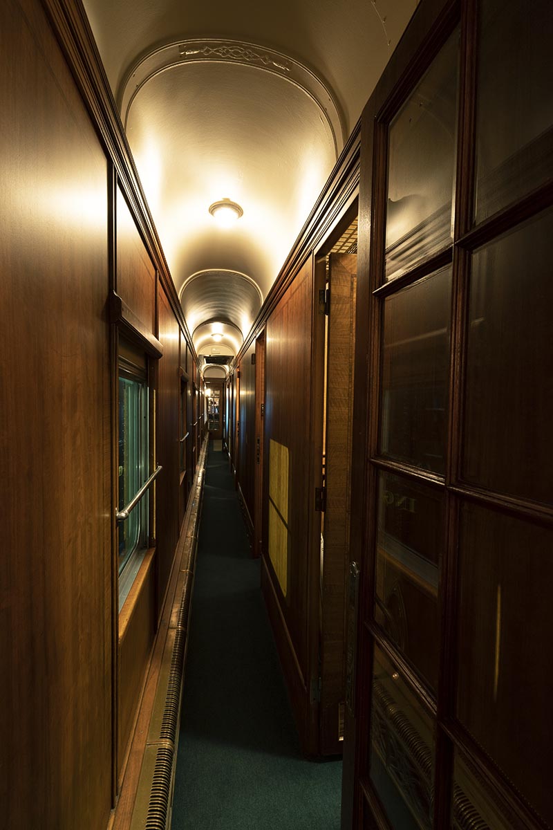 Narrow wood-paneled hallway with arched ceiling