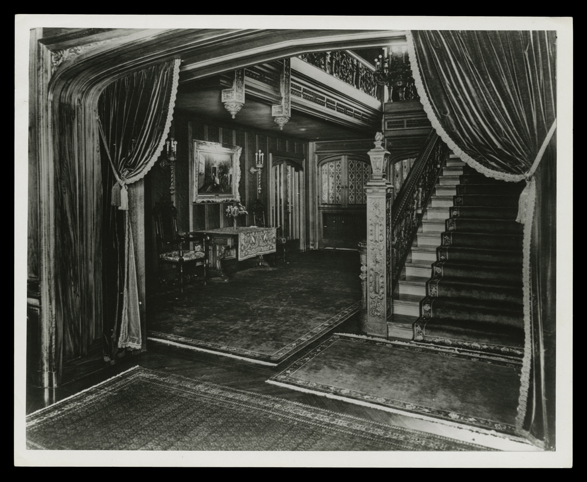 Interior of house with carved wood, heavy draperies, and staircase