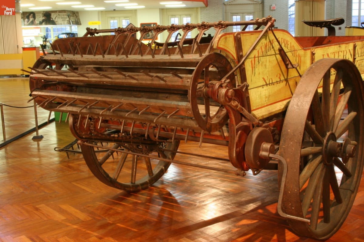 Wooden beater with spikes on the end of a yellow wooden wagon in a large room
