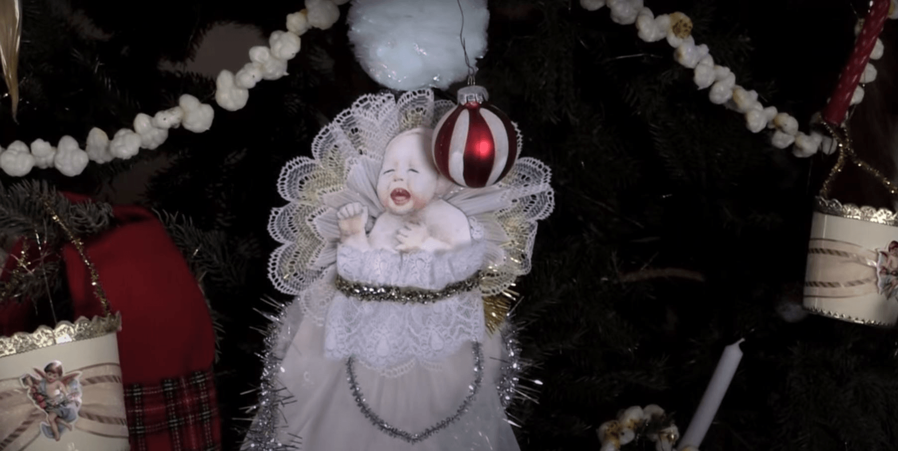 GIF cycling through two images, one black-and-white and one in color, each showing part of a Christmas tree with a large ornament of a screaming baby