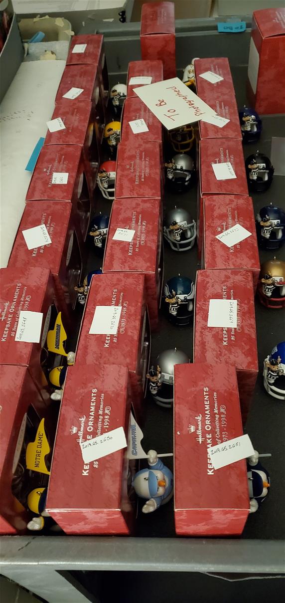 Red boxes lined up, with an ornament (mostly mini football helmets) in front of each