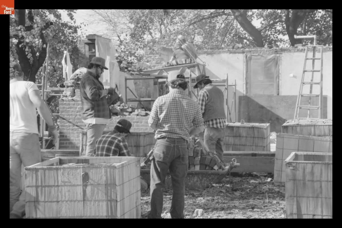 Black-and-white image of several men working on a construction site
