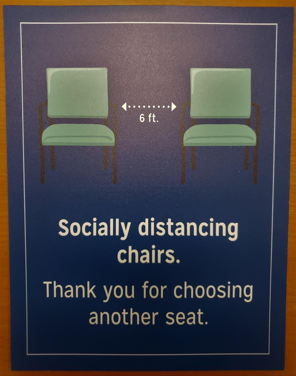 "Socially distancing chairs" sign from Henry Ford Health System Poster showing two green chairs with dotted lines denoting six feet between them; also contains text