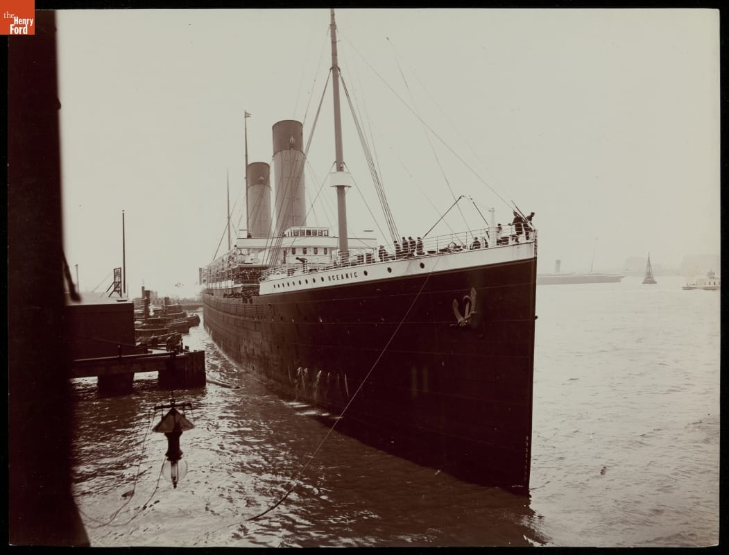 Black-and-white photo of large ship at dock