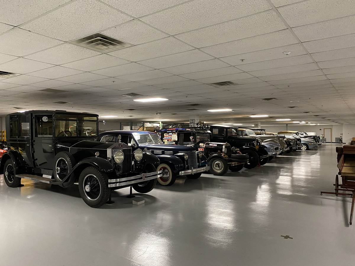 A row of a variety of cars parked in a large room