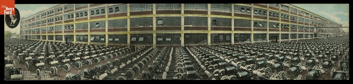 Panoramic image of brick building with many windows behind parking lot completely filled with cars