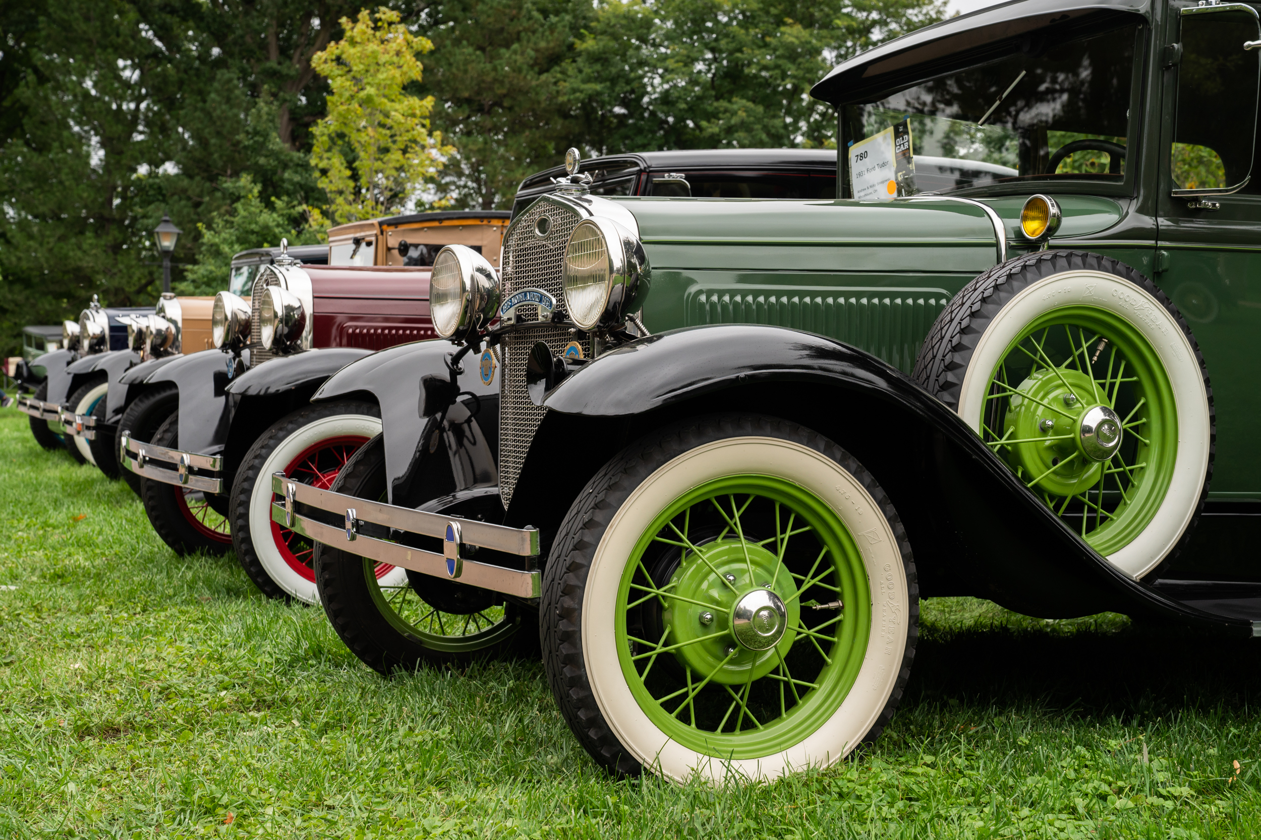 Cars lined up at Old Car Festival Row of antique vehicles parked on green grass