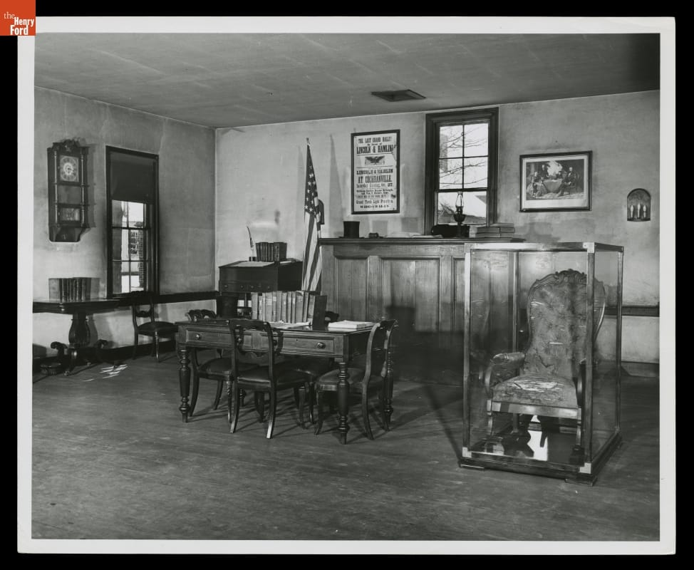 Interior of room containing upholstered rocking chair in case, along with other furniture