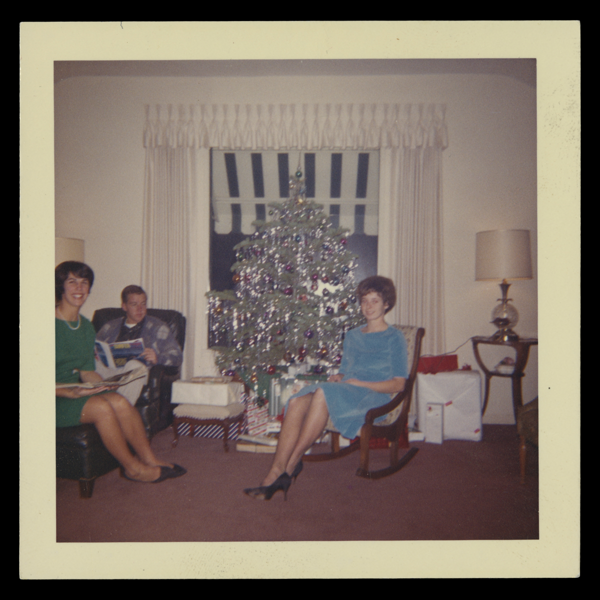 People with Christmas Tree and Gifts, Christmas Day, 1962 Two women and one man seated in a room around a silver aluminum Christmas tree