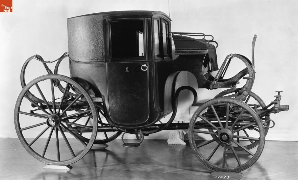 Black-and-white photo of an enclosed carriage with curved lines
