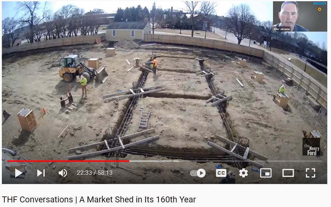 Video screenshot showing a construction site; small "zoom" box in upper right with face of person presumably presenting
