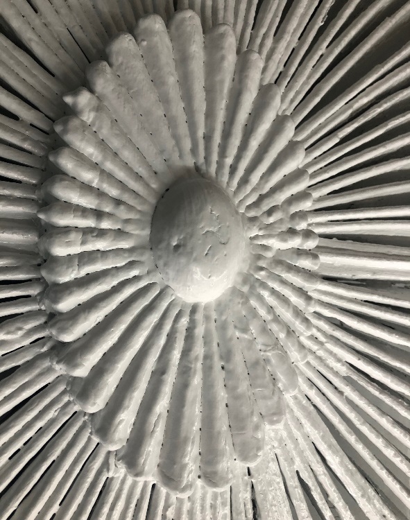 Close-up of architectural element in flower shape with radiating petals/tines coming out from it