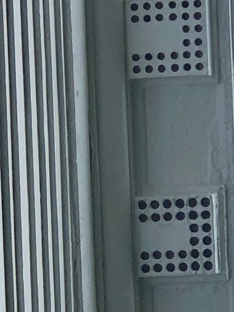 Architectural elements of white boxes with round holes in a "U" pattern in them
