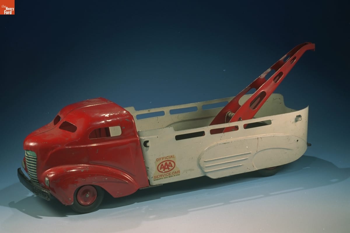 Toy truck with red cabin, white bed, and red winch in bed, with AAA logo on side