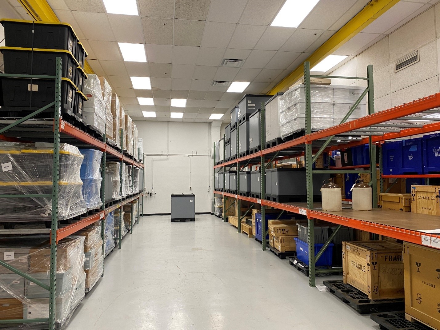 Shelving holds many boxes, crates, and shrink-wrapped pallets