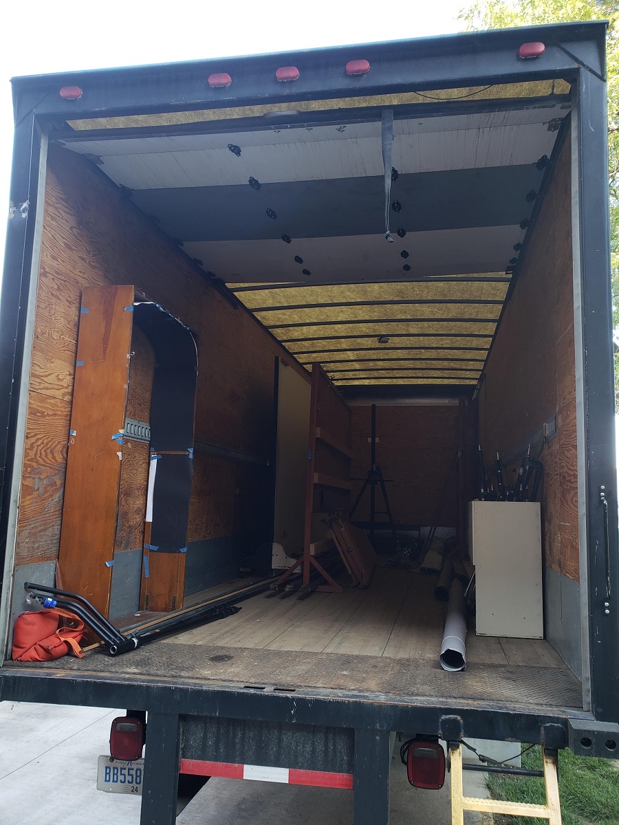Box truck loaded up with our equipment Open back of box truck containing some furniture and equipment