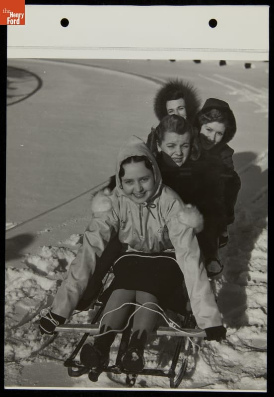 Four women in a sled on a bed of snow