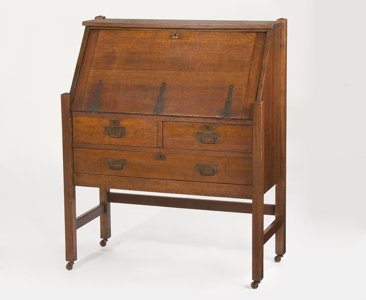 Slant-Front Desk, 1910-1920 Wooden furniture on casters with drawers topped by a slanted flat surface (that presumably folds down to form a desk)