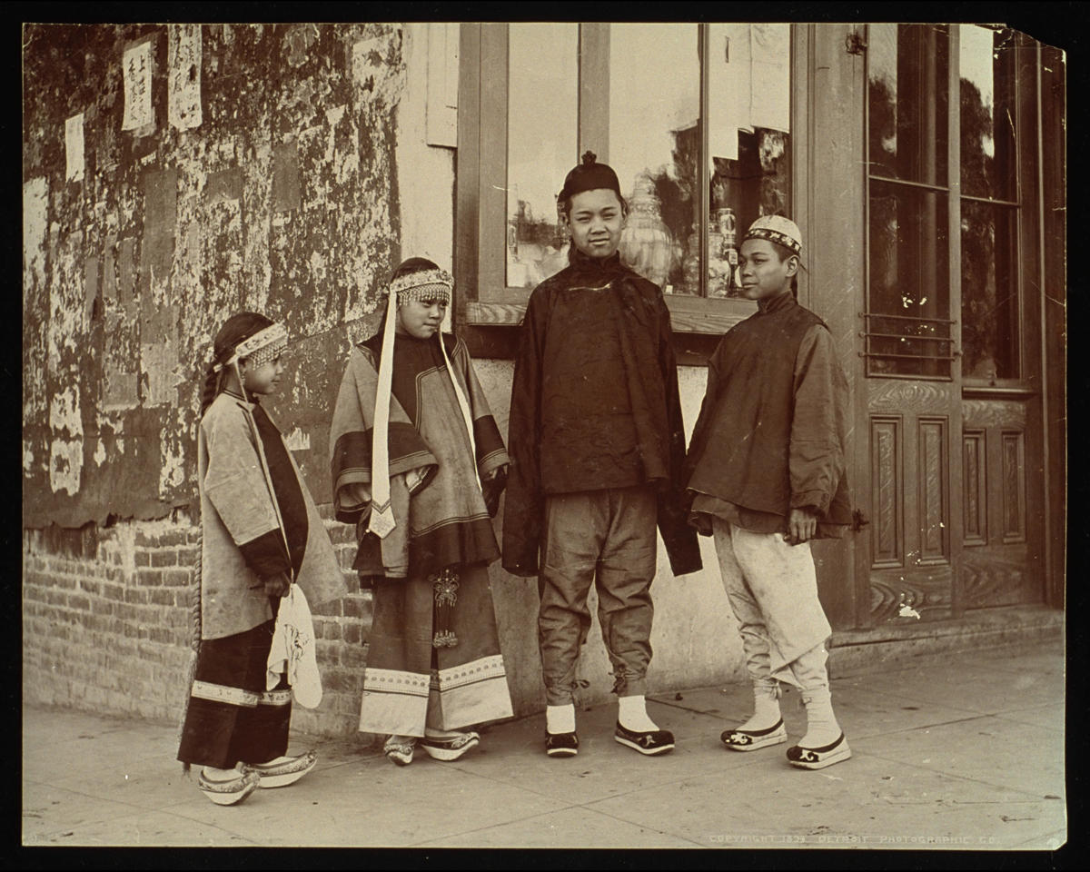 Four Chinese children standing together on a street corner