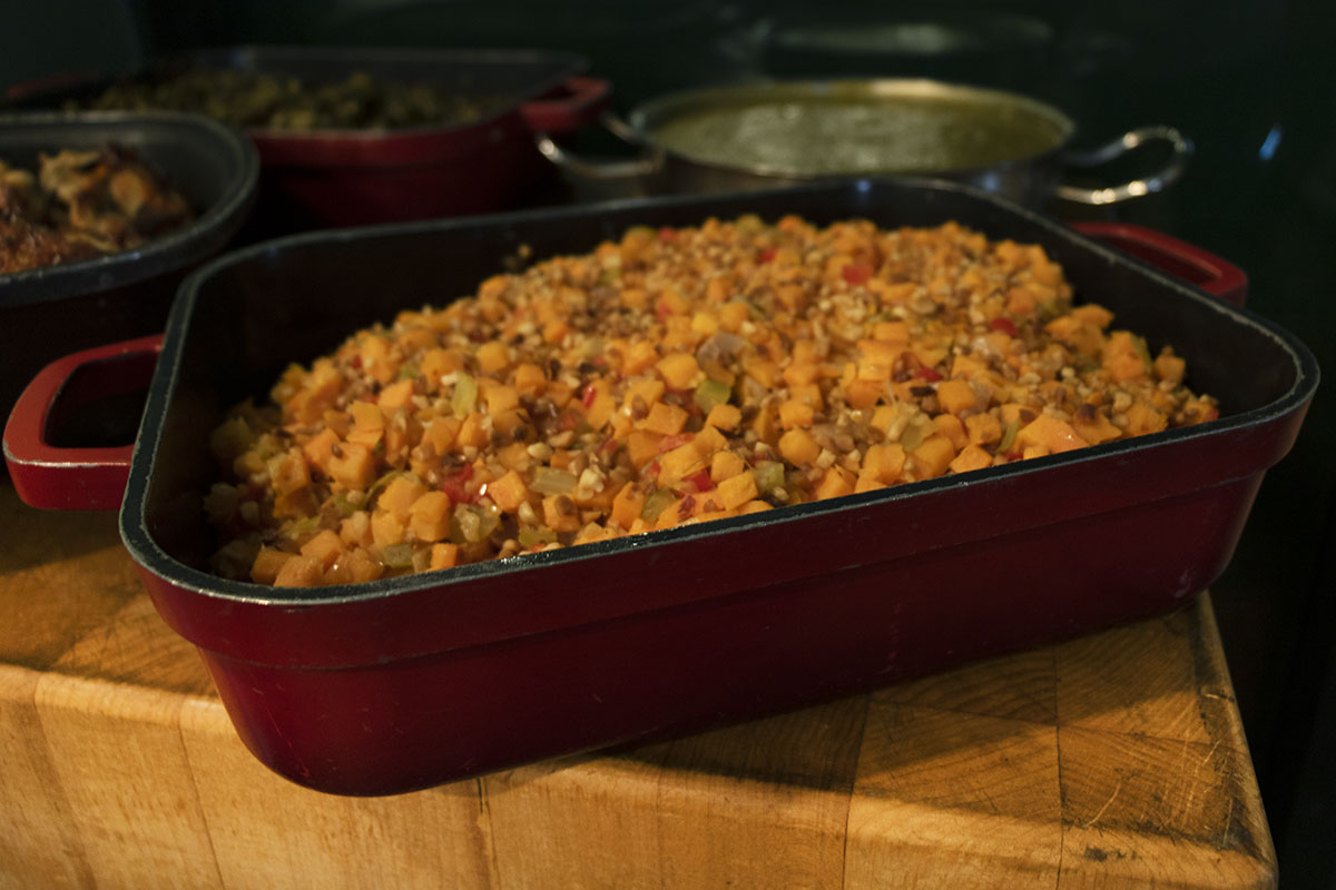 Red dish filled with a vegetable medley; other dishes visible in background