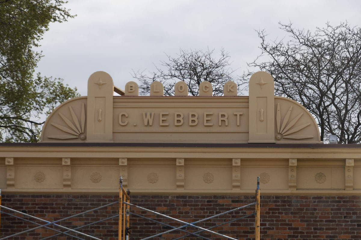 Building roof with large sign with decorative elements and text reading "BLOCK C. Webbert"