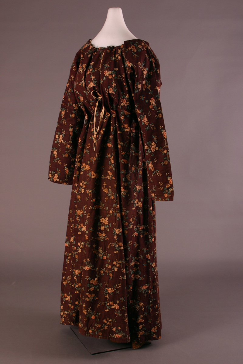 Long-sleeved, floor-length dress gathered at waist and neck, made of brown floral material