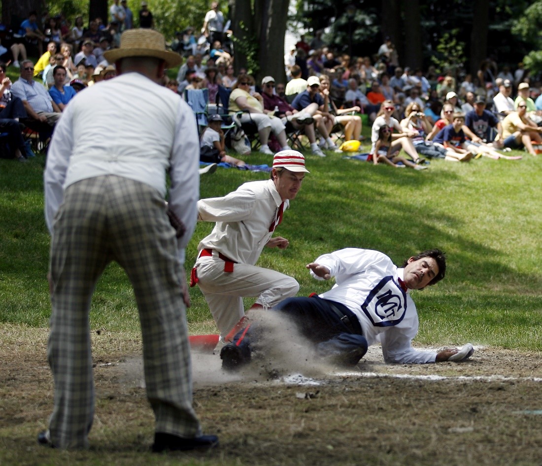Historic Base Ball in Greenfield Village A historic base ball player slides onto a base while other players and a modern crowd looks on