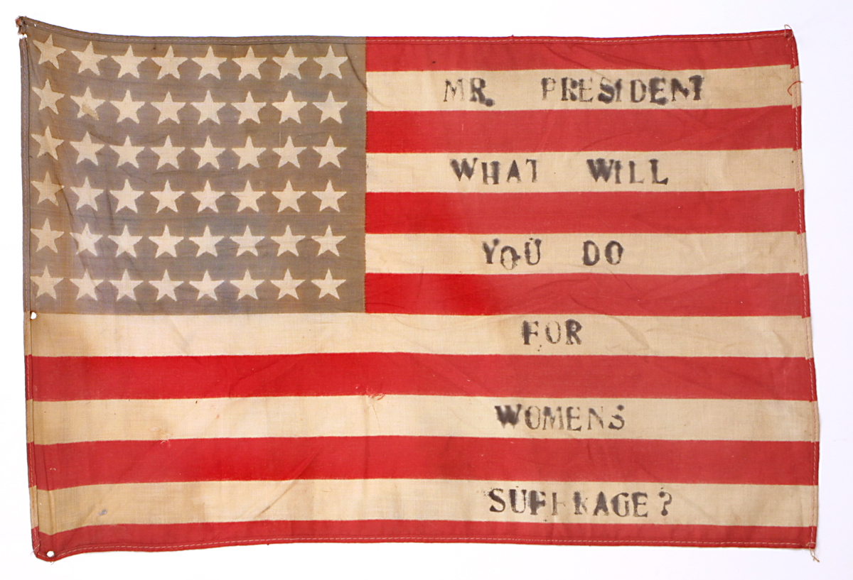 American Flag, "Mr. President, What Will You Do for Women's Suffrage?" circa 1916 48-star American flag with red and white stripes and white stars on a blue field in upper left with text "Mr. President, What Will You Do for Women's Suffrage?" on white stripes