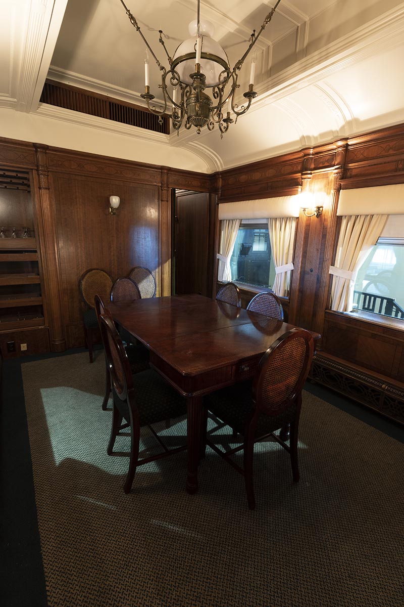Interior of room with wood paneling, arched ceiling, dining table, and chairs