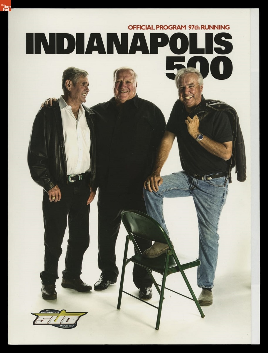 Page with text and photo of three standing men, one with foot up on a folding chair 