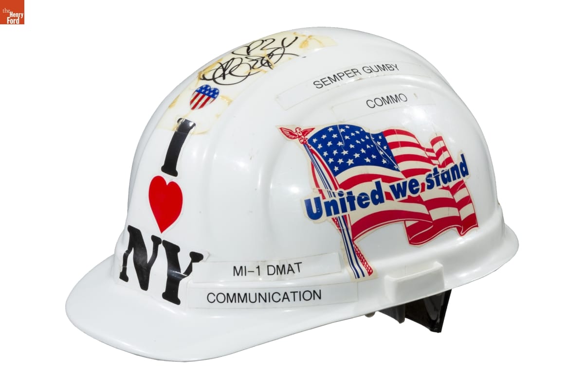 White hard hat with text, decals, and handwriting on it