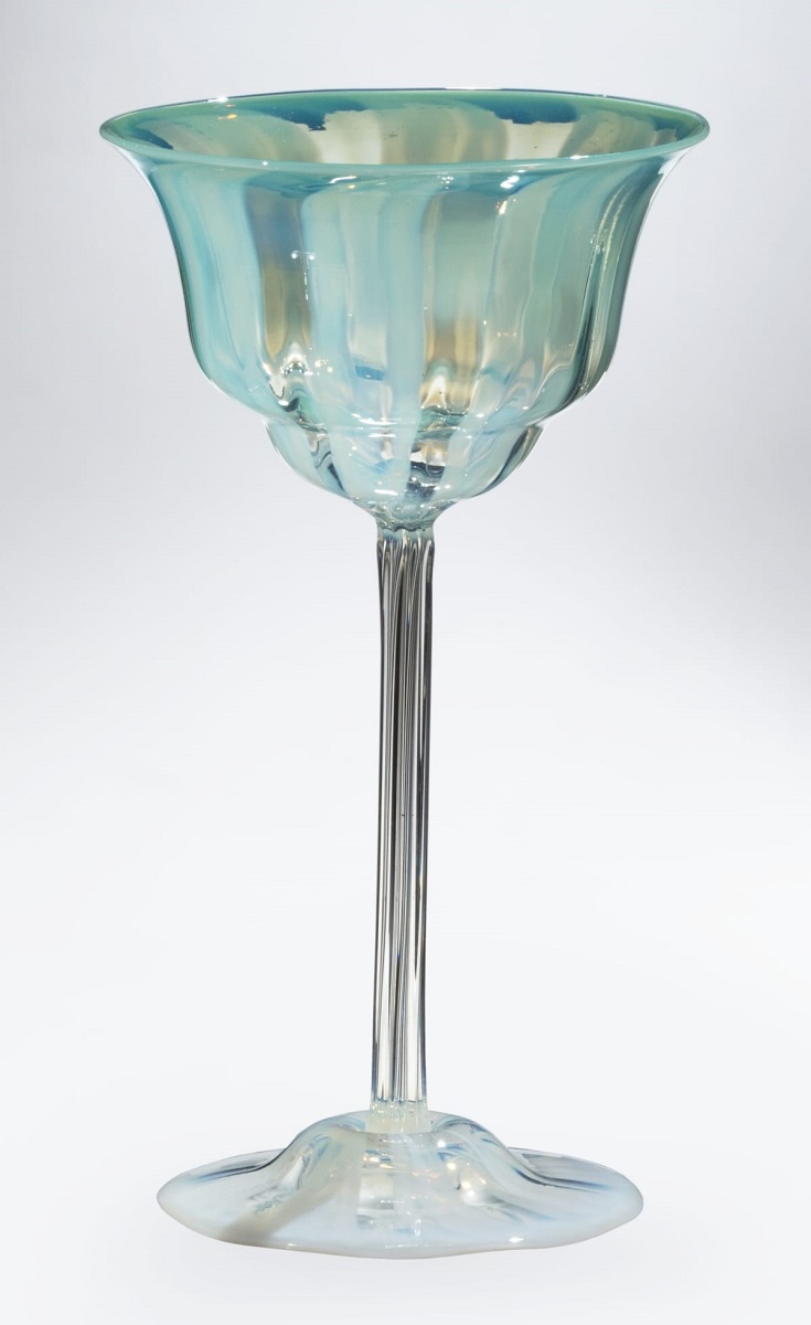 Wine glass with clear base and long stem topped by small body of sea green with striped pattern
