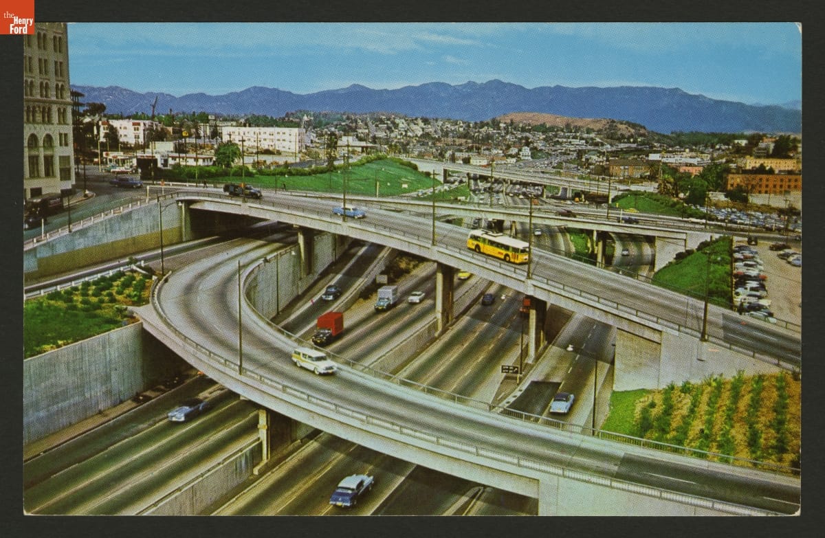 Harbor Freeway in Los Angeles, California, 1956 Color postcard showing a complicated curving multilevel freeway interchange with a city behind it