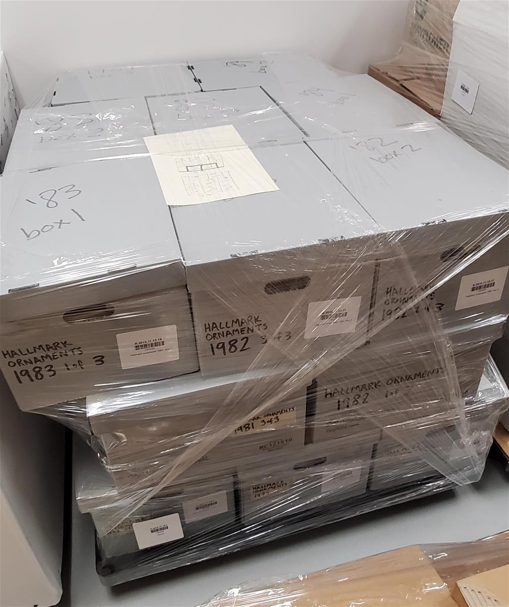 Gray boxes stacked on pallet and secured with clear plastic wrap