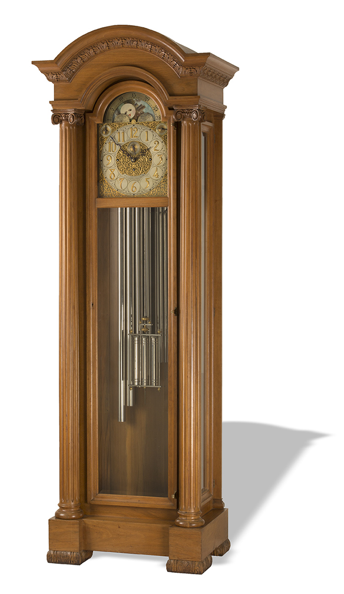 Wooden grandfather clock with glass door and chimes visible inside