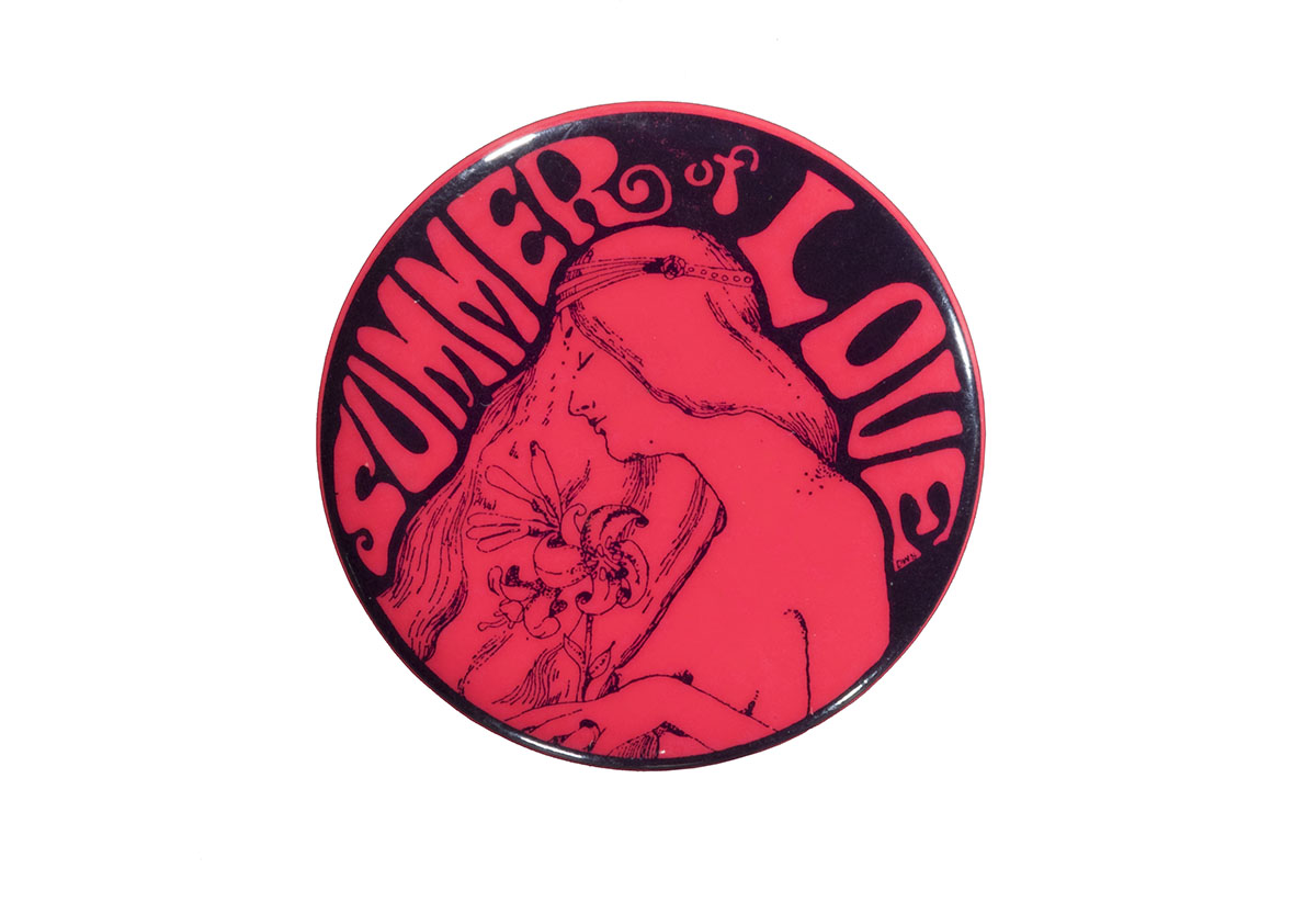 Bright pink button with image of long-haired woman holding flowers and text "Summer of Love"