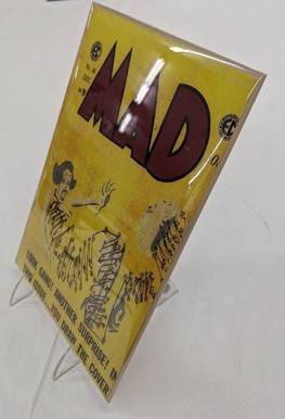 Yellow MAD comic book covered in plastic and on stand
