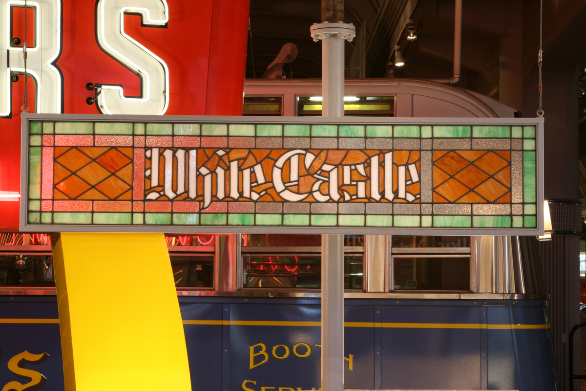 Stained glass sign in red, orange, and green, with white text "White Castle," with other items visible in background