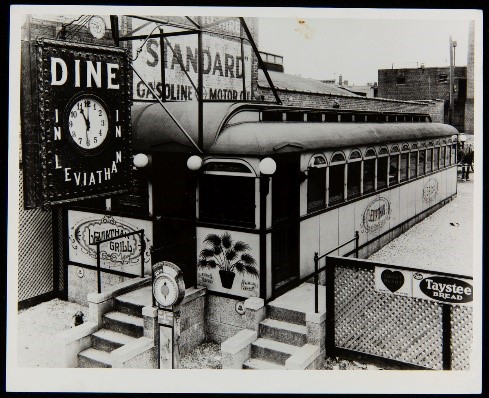 Long low building with windows all along the side; clock hanging in front with text "Dine in Leviathan"